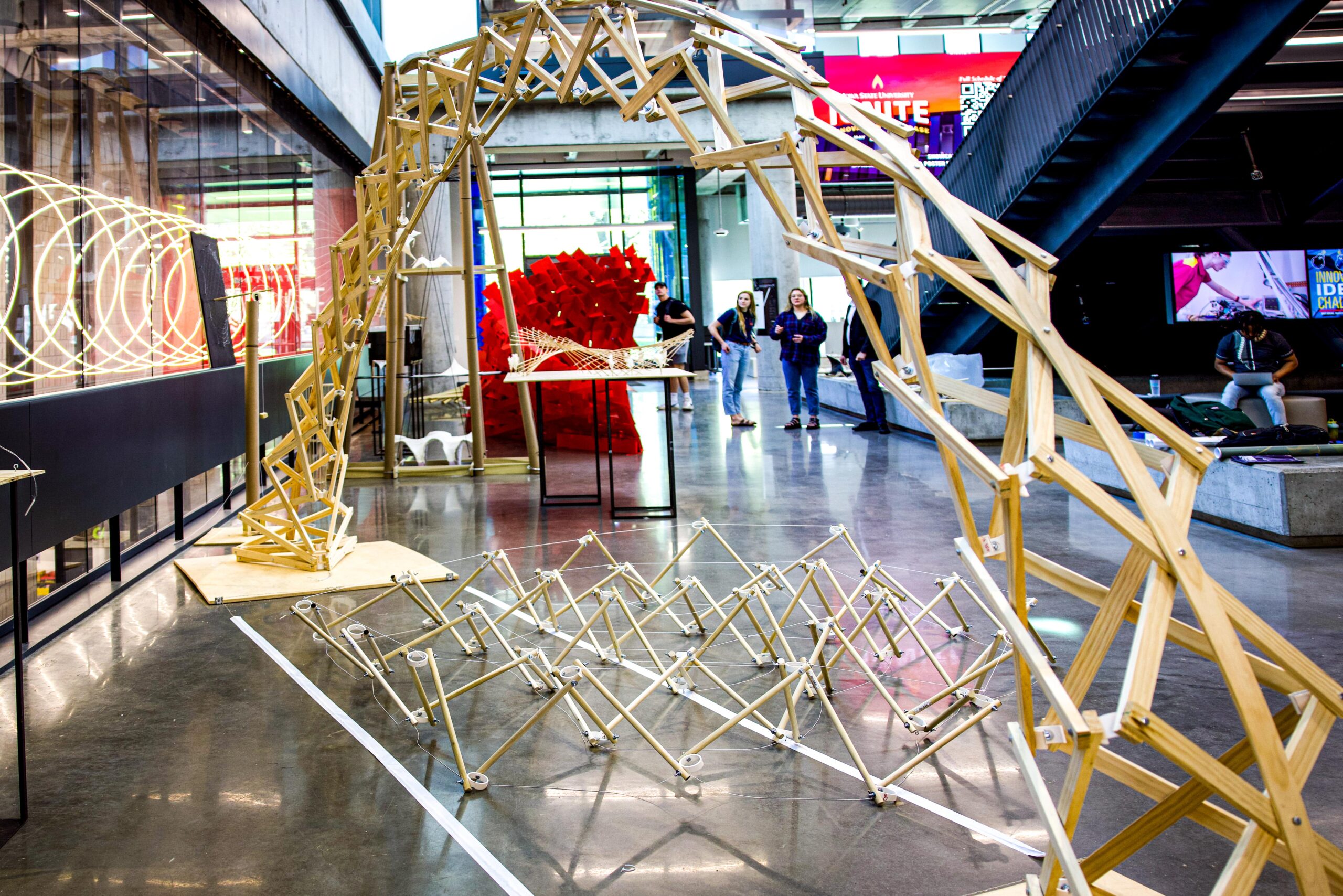 Students view College of Design architecture designs in the atrium of the Student Innovation Center