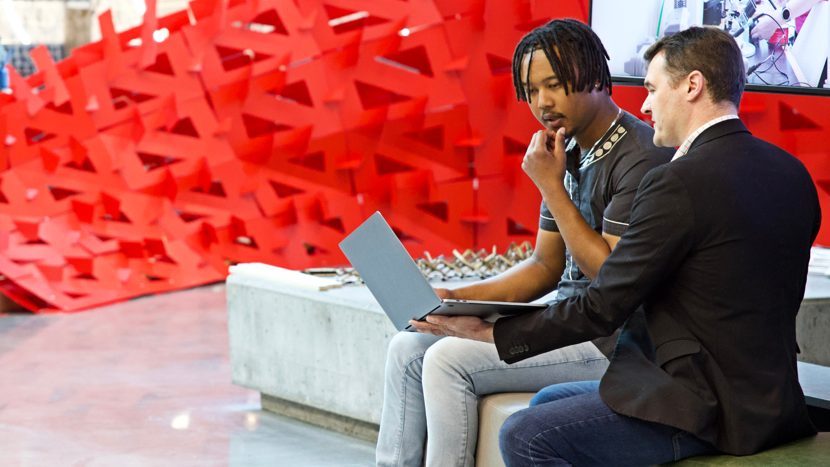 Architecture student and professor collaborating in the Student Innovation Center atrium.